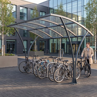Armstrong CHS 10 cycle curved bike shelter in Anthracite Grey at a modern business school campus with bicycles parked