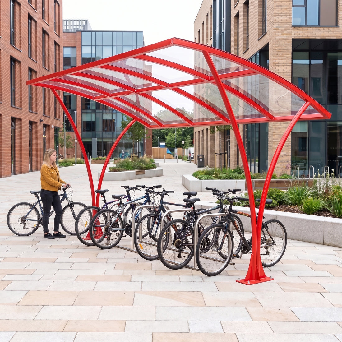 Armstrong CHS 12 cycle curved bike shelter in Traffic Red installed on a university campus with bicycles parked