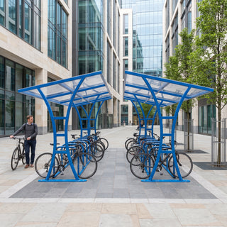 Double-sided 28 bike shelter in traffic blue in an urban pedestrian plaza