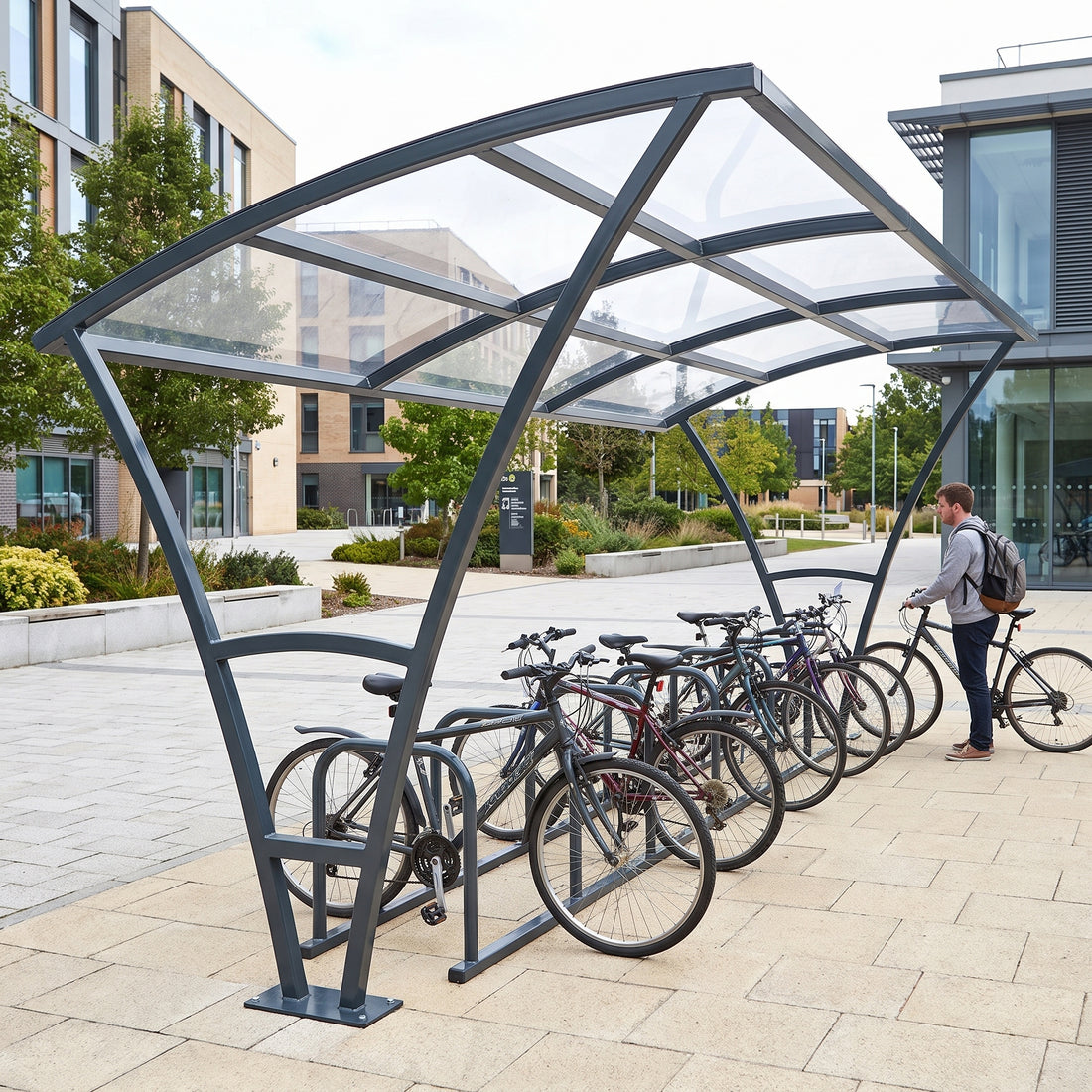 Armstrong 10 cycle bike shelter in Anthracite Grey, end view on a university campus with bicycles parked