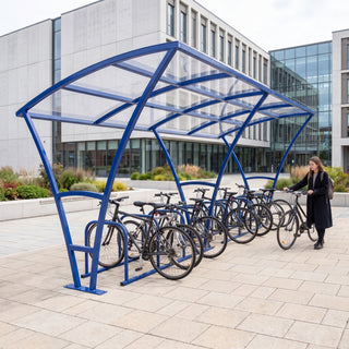 Armstrong 20 cycle bike shelter in Ultramarine Blue in a modern university library courtyard with bicycles parked