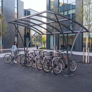 Armstrong CHS 12 cycle curved bike shelter in Anthracite Grey at a modern business school campus with bicycles parked
