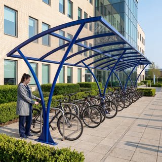 Armstrong CHS 30 cycle curved bike shelter in Ultramarine Blue at a UK hospital with a nurse unlocking her bike