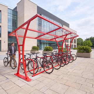 14 bike red cycle shelter with clear roof and bicycles parked at a modern hospital